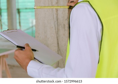 Inspection. young foreman builder, engineer or inspector checking and inspecting with clipboard and measuring tape at construction site building interior project, contractor and engineering concept - Shutterstock ID 1572996613
