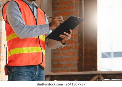 inspector checking structure of new property and taking note in the clipboard for review and fix the house before sell to client
