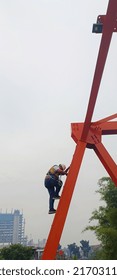 An Inspector Climbing A Bridge Pylon