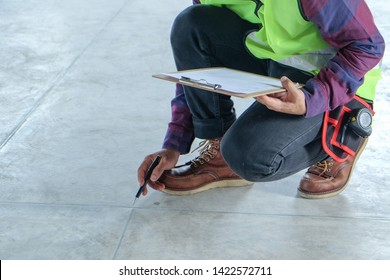 Inspector or engineer is checking and inspecting floor appearance and pointing to the surface. Inspection concept - Shutterstock ID 1422572711