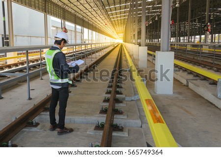 Inspector (Engineer) checking railway or track in depot of skytrain 