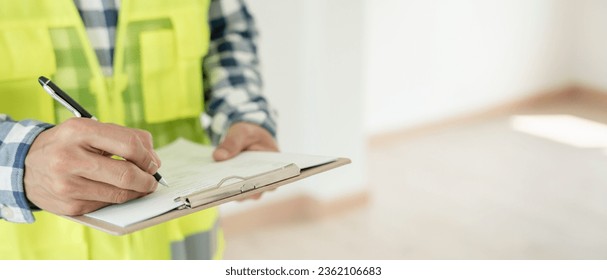 inspector or engineer is inspecting construction and quality assurance new house using a checklist. Engineers or architects or contactor work to build the house before handing it over to the homeowner - Shutterstock ID 2362106683