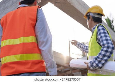 inspector or engineer is inspecting construction and quality assurance new house using a blue print. Engineer or architects or contactor work to build the house before handing it over to the homeowner