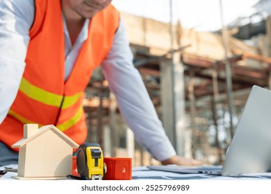 inspector or engineer is inspecting construction and quality assurance new house using computer. Engineers or architects or contactor work to build the house before handing it over to the homeowner