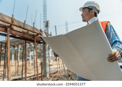 inspector or engineer is inspecting construction and quality assurance new house using a blue print. Engineer or architects or contactor work to build the house before handing it over to the homeowner