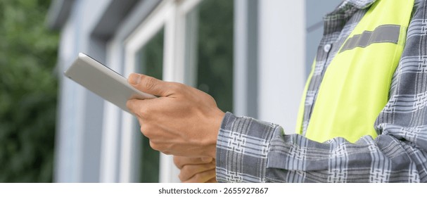 inspector or engineer is inspecting construction and quality assurance new house using a tablet. Engineers or architects or contactor work to build the house before handing it over to the homeowner