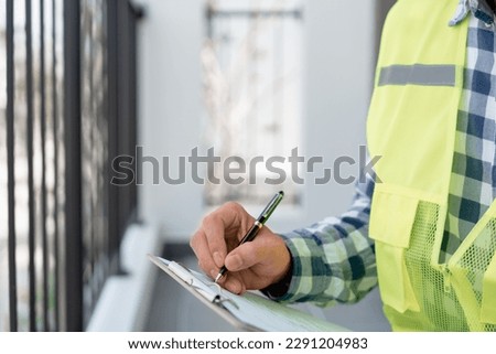 inspector or engineer is inspecting construction and quality assurance new house using a checklist. Engineers or architects or contactor work to build the house before handing it over to the homeowner