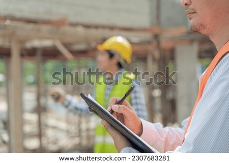 inspector or engineer is inspecting construction and quality assurance new house using a checklist. Engineers or architects or contactor work to build the house before handing it over to the homeowner