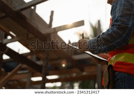 inspector or engineer is inspecting construction and quality assurance new house using a checklist. Engineers or architects or contactor work to build the house before handing it over to the homeowner