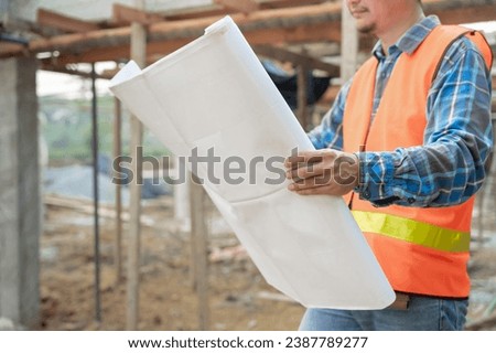 inspector or engineer is inspecting construction and quality assurance new house using a blue print. Engineer or architects or contactor work to build the house before handing it over to the homeowner