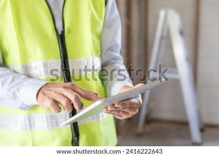 inspector or engineer is inspecting construction and quality assurance new house using a tablet. Engineers or architects or contactor work to build the house before handing it over to the homeowner