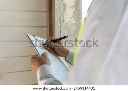 inspector or engineer is inspecting construction and quality assurance new house using a checklist. Engineers or architects or contactor work to build the house before handing it over to the homeowner