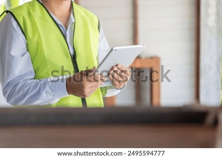 inspector or engineer is inspecting construction and quality assurance new house using a tablet. Engineers or architects or contactor work to build the house before handing it over to the homeowner