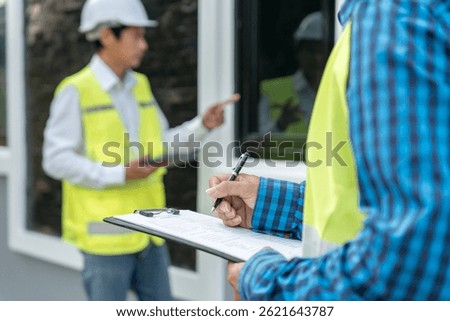 inspector or engineer is inspecting construction and quality assurance new house using a checklist. Engineers or architects or contactor work to build the house before handing it over to the homeowner