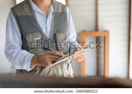 inspector or engineer is inspecting construction and quality assurance new house using a checklist. Engineers or architects or contactor work to build the house before handing it over to the homeowner
