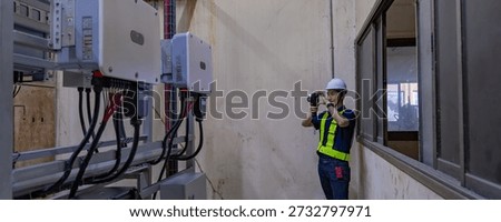 Inspector examination of photovoltaic modules using a thermal imaging camera. Engineer Checking Temperature the string cables input to inverter solar panel used thermos infrared.