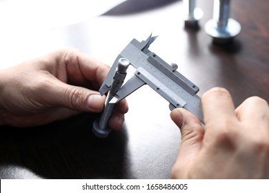 Inspector is measuring diameter of the bolts with a manual verniel caliper micrometer gauge. The Vernier caliper is an extremely precise measuring instrument; the reading error is 1/20 mm = 0.05 mm.