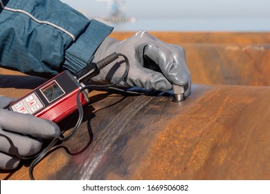 Inspector Is Measuring Thickness Of The Pipe Material From Near To Weld With A Portable Ultrasonic Wall Thickness Measurement Gauge. It Is A Method Of Performing Non Destructive Measurement (gauging).