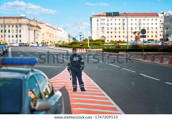 Inspector\
of traffic police in uniform with sign DPS on duty. Traffic police\
Inspector enforcing traffic safety compliance on roads. Inscription\
on uniform DPS - Department of traffic\
police