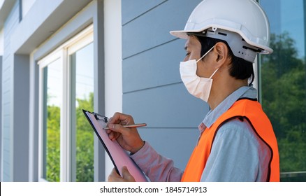 Inspectors or engineers are wearing an anti-virus mask and checking the building structure and the requirements of the wall paint. After the renovation is completed