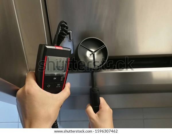 The inspectors are using anemometer\
to measure the air velocity of the hood in the\
kitchen.
