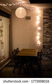 Inspiration home decor idea, with warm string lights and a globe solar lantern hanging on the ceiling in the front porch, over outdoor furniture, warming the backyard or garden in summer nights.
