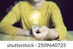 Inspiration of ideas for sustainable business development.Idea innovation and inspiration concept. Hand of man holding illuminated light bulb, concept creativity with bulbs that shine glitter.