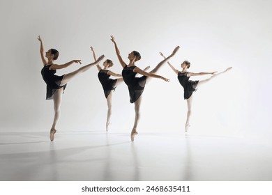 Inspiration. Young teen girls, graceful ballerinas in back costumes standing on pointe, training, performing complex ballet moves. Concept of ballet art, dance studio, classical style, youth - Powered by Shutterstock