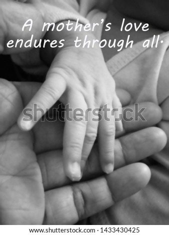 Inspirational mother quote- A mothers love endures through all. With blurry image of a fragile little baby new born hand and fingers in her his mother hand in black and white.