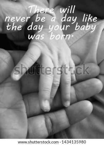 Inspirational mother quote- There will never be a day like the day your baby was born. With blurry image of a fragile little baby new born hand and fingers in her his mother hand in black and white.