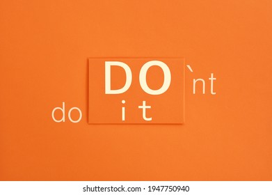  Inspirational and motivational quote with the juxtaposition "Do it, don't do it" on an orange background close-up