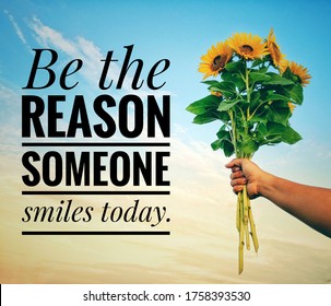 Inspirational quote - Be the reason someone smiles today. With a hand holding a bunch of sunflowers against bright blue sky background. Motivational text message with flowers and sky background. - Shutterstock ID 1758393530
