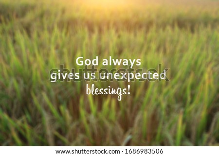 Inspirational quote - God always gives us unexpected blessings. With blurry background of dreamy morning sunrise light over the field. Believe in God concept.