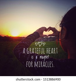 Inspirational quote - a grateful heart is a magnet for miracles. With young girl making hand love sign against the sunset. Life words of wisdom concept with human and nature background.
