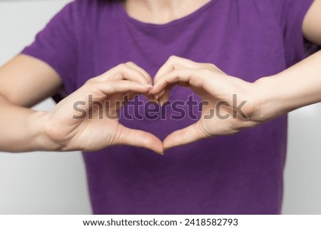 Inspire inclusion. Zoomers symbolize love. Woman finger heart dressed purple t-shirt. Hand showing heart. International Women's Day 2024, inspireInclusion.