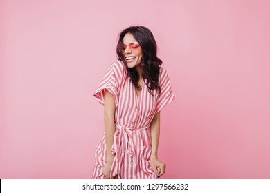 Inspired brown-haired woman in summer dress laughing with eyes closed. Portrait of refined latin girl chilling during romantic photoshoot - Powered by Shutterstock