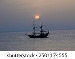 Inspired by 18th century, a galleon in the agean sea with the sun going down behind it. Romantic.