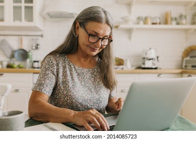 Inspired Older Woman Typing On Laptop. Elderly Smiling Lady Composing Story On Device, Work From Home. Hobby For Soul, Creativity, Inspiration, Technology Concept