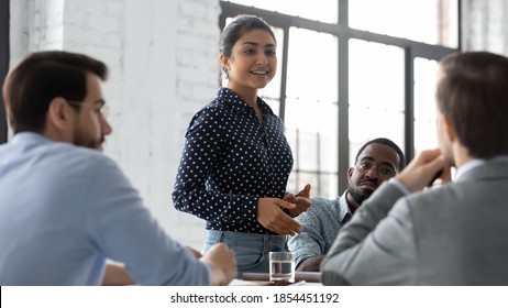Inspired speaker. Confident indian businesswoman convincing thoughtful multiethnic business partners on negotiations, young mixed race female responsible executive making report on corporate briefing
