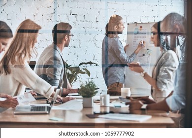 Inspired to work hard. Modern young man conducting a business presentation while standing behind the glass wall in the board room - Powered by Shutterstock