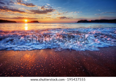Inspiring and dynamic ocean bay sunrise on a secluded beach with fabulous sand and breaking wave