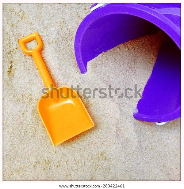 Instagram filtered image of a to shovel and pail in\
the sand