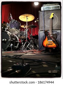 Instagram Style Image Of A Guitar And Drums On Stage