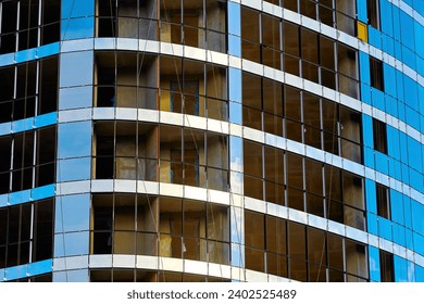 Install double glazed window on high-rise building. Building construction, glazing facade of new residential building. Mount insulated glass panels on facade of high-rise building