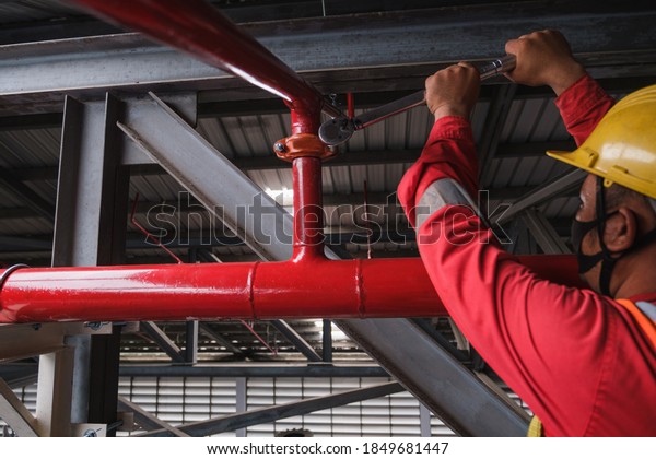 Install fire sprinkler system. In the industrial\
plant, pipe assembly, red fire pipe, fire protection contractors\
Using Scissor Lift High\
work