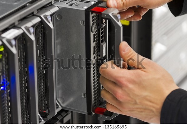 Install or remove a blade server in a blade\
chassis in a rack. Shot in a data\
center.