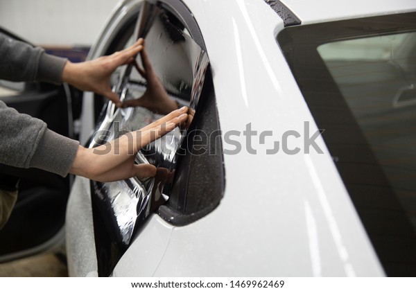 Install windows film on the car. Tinted Windows of\
the car.