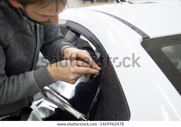 Install windows film on the car. Tinted Windows of\
the car.