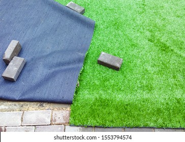 Installation Of Artificial Turf Or A Modern Synthetic Grass Carpet. Selective Focus.