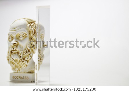 An installation consisting of Socrates statue and prism on white background.